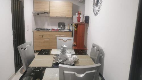 a dining room with a table and chairs and a kitchen at WALOJO¡ Acogedor Apartamento, Excelente ubicación in Neiva
