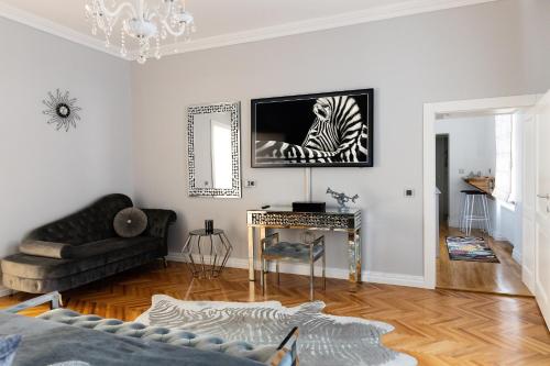 a living room with a couch and a television on a wall at Fancy Flats in Sibiu