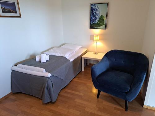 a bedroom with a bed and a blue chair at Motell Svinesundparken in Halden