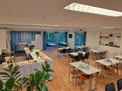 une salle à manger avec des tables, des chaises et une table dans l'établissement Motell Svinesundparken, à Halden