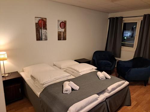 a bedroom with a bed and two chairs at Motell Svinesundparken in Halden