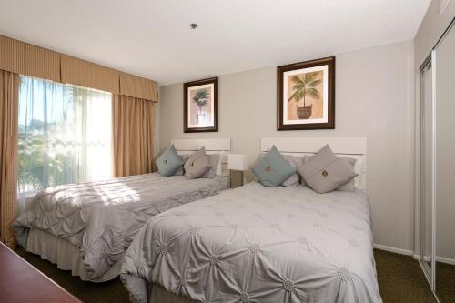 pokój hotelowy z 2 łóżkami i oknem w obiekcie Parc Corniche Condominium Suites w Orlando