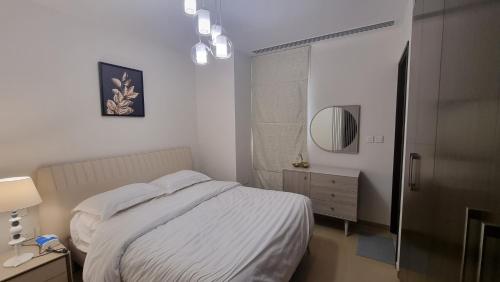 a white bedroom with a bed and a mirror at Two bedroom Apartment Muscat Bay in Muscat