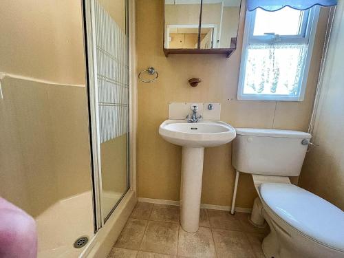 a bathroom with a toilet and a sink and a shower at Spacious Caravan For Hire With Decking By The Beach In Suffolk Ref 40094nd in Lowestoft