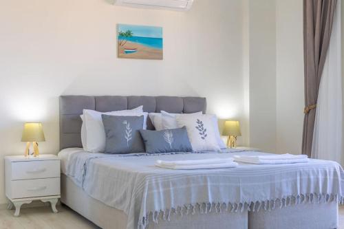 a bed with blue and white sheets and pillows at Villa Cavit Bey in Marmaris