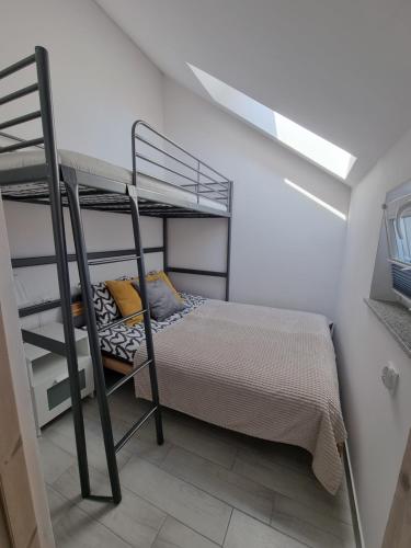 1 dormitorio con litera y escalera en Nowe apartamenty Kuźnica Hel, en Kuźnica