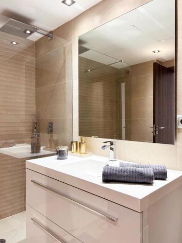 La salle de bains est pourvue d'un lavabo et d'un grand miroir. dans l'établissement Maribel Apartamento Moderno, à Marbella