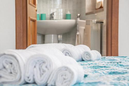 un mucchio di asciugamani su un letto in bagno di Budget Beds ad Alghero