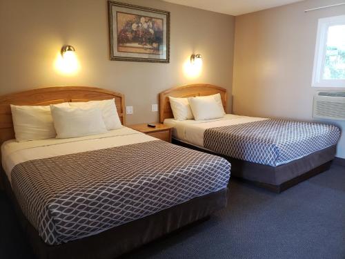 a hotel room with two beds and a window at Lamplighter Inn in Three Hills