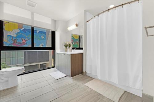 y baño con aseo y cortina de ducha. en Devereaux Miami Luxury One-Bedroom and Studios en Miami
