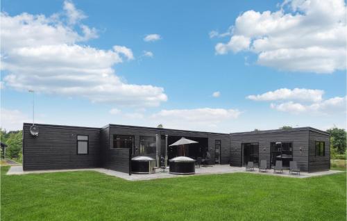 a black house with a lawn in front of it at 6 Bedroom Nice Home In Glesborg in Glesborg