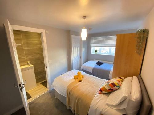 ein Schlafzimmer mit 2 Betten und einem Teddybär auf dem Bett in der Unterkunft Studio Apartment in Dartford, 5mins to Stn & High Str. in Kent
