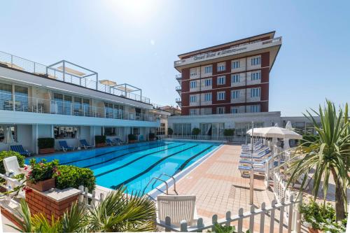 une grande piscine en face d'un hôtel dans l'établissement Grand Hotel & Riviera, à Lido di Camaiore