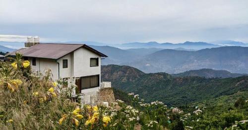 a house on the side of a hill with mountains at Villa MYSA in Rāmgarh
