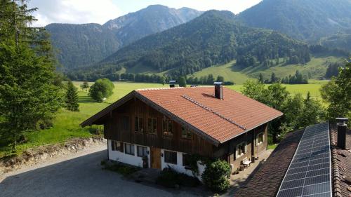 een huis met zonnepanelen voor een berg bij Idyllisches Berg-Chalet mit Panoramablick in Bayrischzell