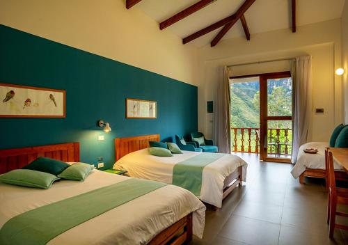 a bedroom with two beds and a large window at Gocta Andes Lodge in Cocachimba