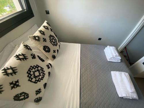 a bedroom with a bed with pillows on it at Kaleo Chios Luxury Apartments in Chios