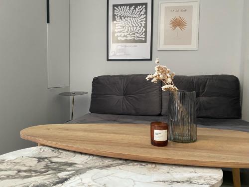 a wooden table with a vase with flowers on it at Kaleo Chios Luxury Apartments in Chios