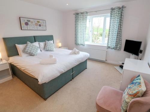 a bedroom with a large bed and a television at Sandbanks in Penzance