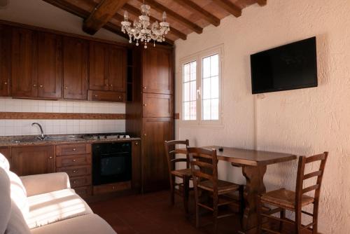 a kitchen with a table and chairs and a tv at Case vacanze Santamargherita in Castiglione della Pescaia