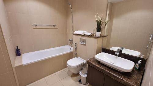 a bathroom with a sink and a tub and a toilet at Two bedroom Apartment Muscat Bay in Muscat