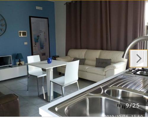 cocina y sala de estar con mesa y sofá en Pretty House, en Casamassima