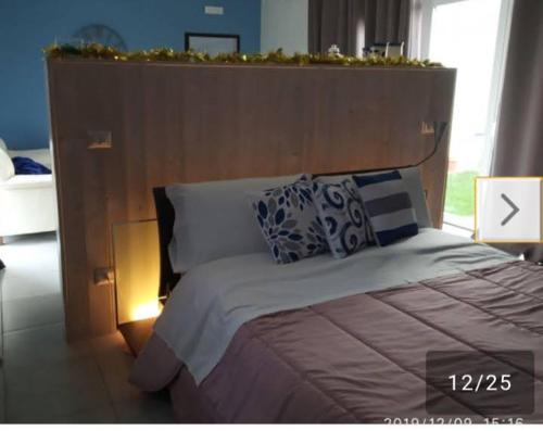 1 dormitorio con 1 cama grande y cabecero de madera en Pretty House, en Casamassima