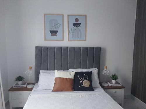 a bedroom with a bed with a gray headboard at C.leslie_homes in Bamburi