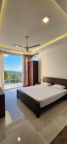 a bedroom with a large bed and a large window at The Cloud Hanthana, Kandy in Kandy