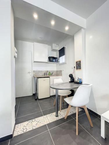 une cuisine avec une table et des chaises dans une pièce dans l'établissement Logement cosy cuisine / terrasse / BBQ, à Ollioules