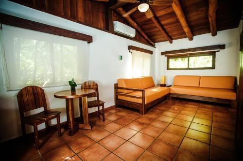 a living room with a couch and a table and chairs at Hotel Rancho Encantado in Bacalar