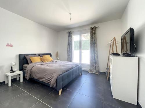 une chambre avec un lit et une télévision dans l'établissement Logement cosy cuisine / terrasse / BBQ, à Ollioules