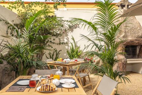 un patio esterno con tavolo, sedie e piante di Boutique Marconi a Quartu SantʼElena