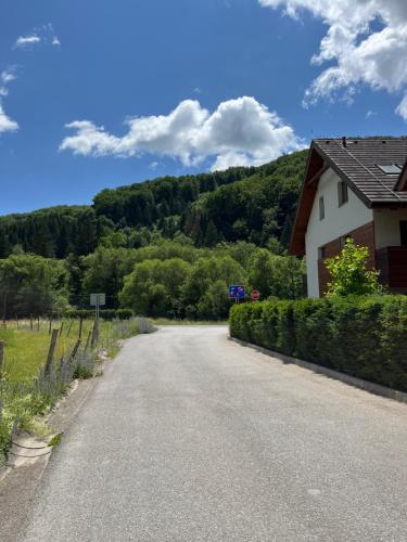 uma estrada que leva a uma casa com uma montanha ao fundo em Ski eden em Mýto pod Ďumbierom