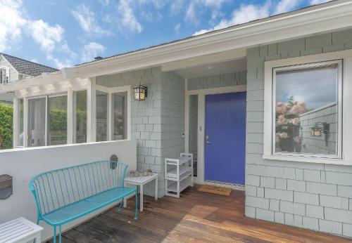 ein Haus mit einer blauen Bank auf einer Veranda in der Unterkunft 3897 Driftwood home in Carmel