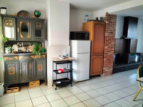 a kitchen with a refrigerator and a table in it at House close to the city center in Mons