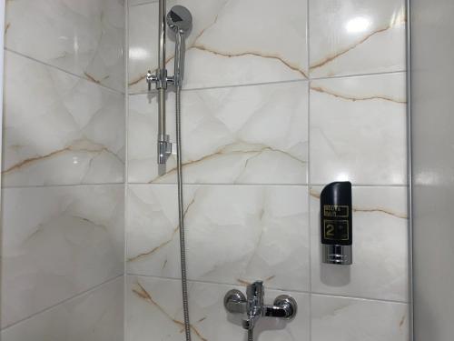 a bathroom with a shower with a phone in it at Louis Hotels in Schmitten