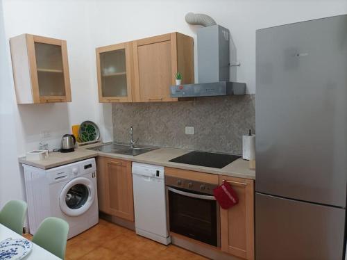 a kitchen with a refrigerator and a washing machine at Casa Aprosio, appartamento luminoso in centro a Ventimiglia, a 5 min dal mare e dal treno in Ventimiglia