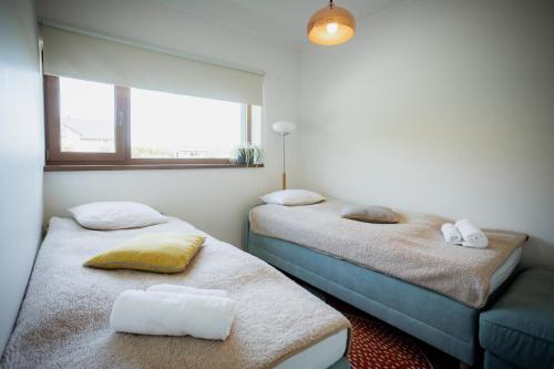 two twin beds in a room with two windows at Luxury apartment close to the sea in Kuressaare