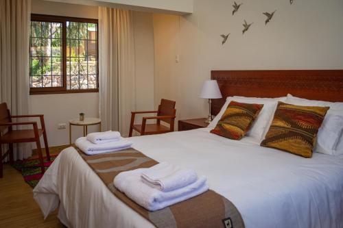 a bedroom with a large bed with towels on it at Inkantari Boutique Hotel in Cusco
