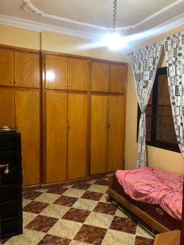 a bedroom with wooden cabinets and a bed at Hay arabie al3irfan in Alimadene