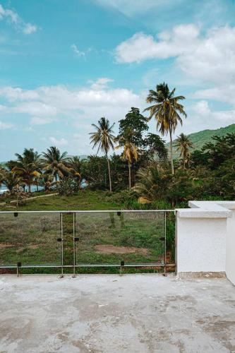 a fence with palm trees in the background at Blissful Tides in Hope Bay