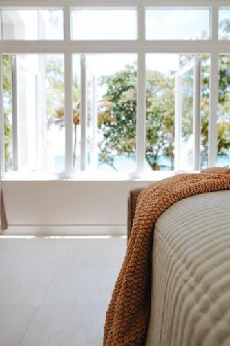a bed sitting in front of a large window at Blissful Tides in Hope Bay