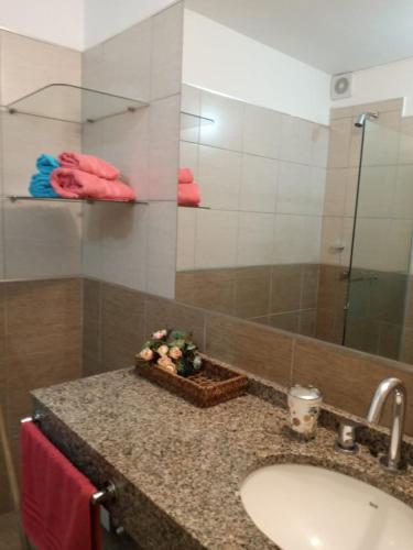 um balcão de casa de banho com um lavatório e um espelho em Departamentos NG CENTRO Carlos Paz em Villa Carlos Paz