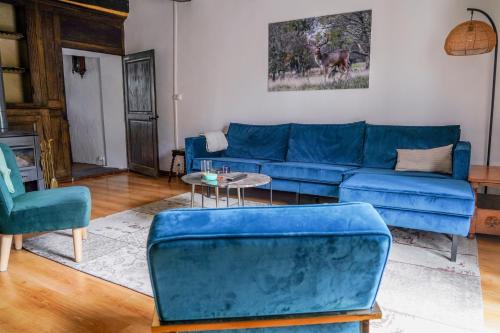 un salon avec un canapé bleu et des chaises dans l'établissement Maison Ainvelle - with Sauna, à Ainvelle