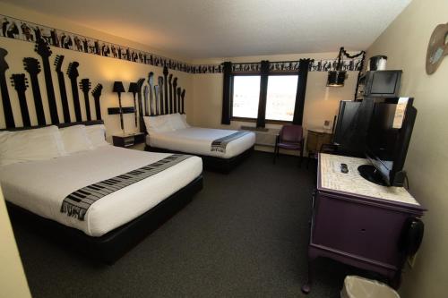 a hotel room with two beds and a flat screen tv at Riverside Inn in Cold Spring