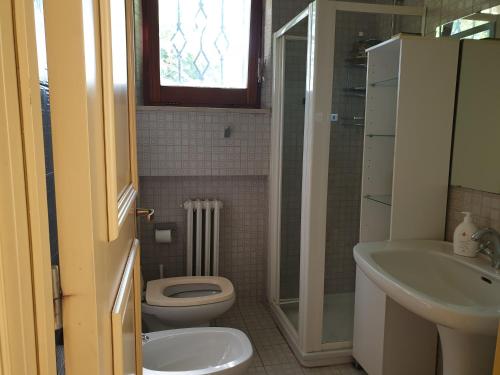 une salle de bain avec toilettes et lavabo dans l'établissement Ai tre tigli con giardino privato, à Sirolo
