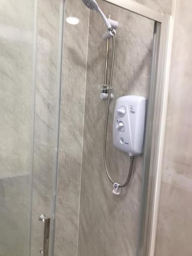 a shower with a shower head in a bathroom at Ballyliffin bungalow with stunning beach views in Ballyliffin