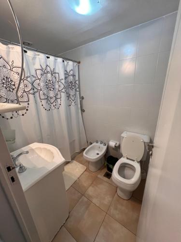 a white bathroom with a toilet and a sink at Hermoso Depto para 4 o 6 personas in Salta