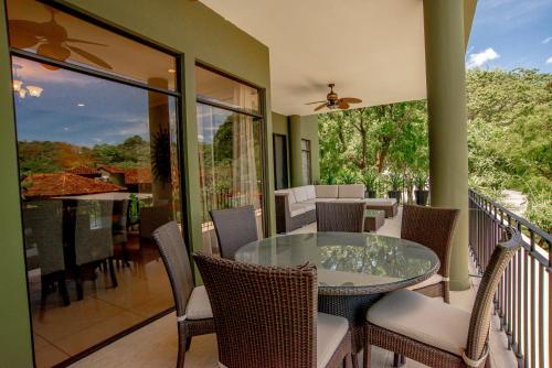 a balcony with a glass table and chairs at Carao T5-2 Luxury Apartment Adults Only - Reserva Conchal in Playa Conchal